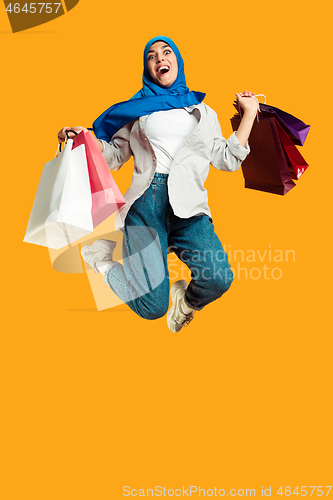 Image of Portrait of young muslim woman isolated on yellow studio background