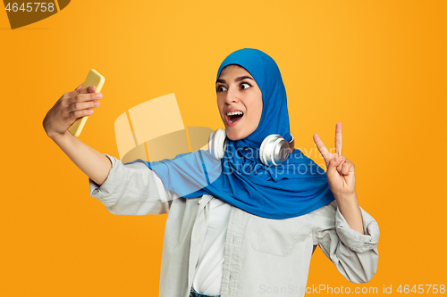 Image of Portrait of young muslim woman isolated on yellow studio background