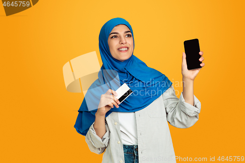 Image of Portrait of young muslim woman isolated on yellow studio background