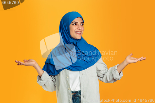 Image of Portrait of young muslim woman isolated on yellow studio background