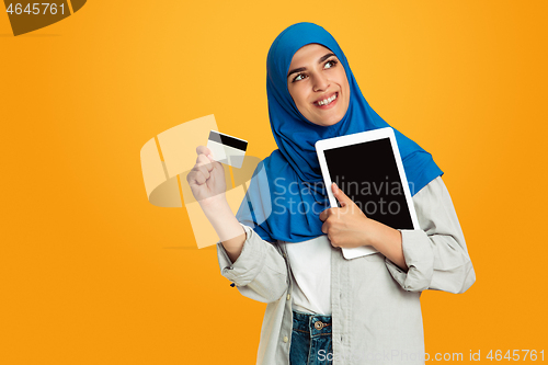 Image of Portrait of young muslim woman isolated on yellow studio background