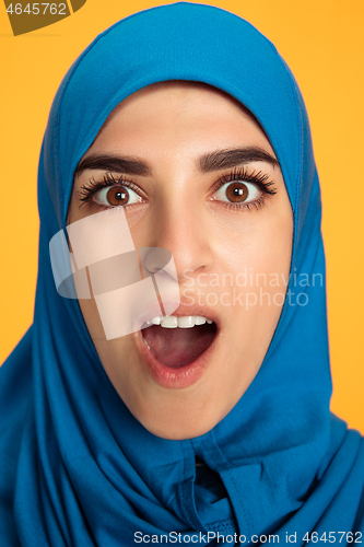 Image of Portrait of young muslim woman isolated on yellow studio background