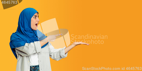 Image of Portrait of young muslim woman isolated on yellow studio background