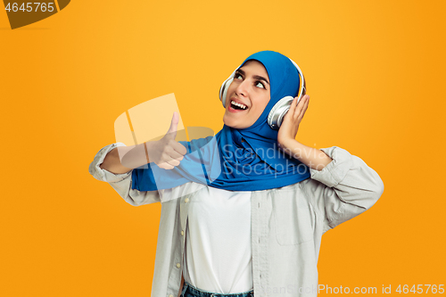 Image of Portrait of young muslim woman isolated on yellow studio background