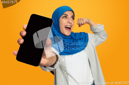 Image of Portrait of young muslim woman isolated on yellow studio background