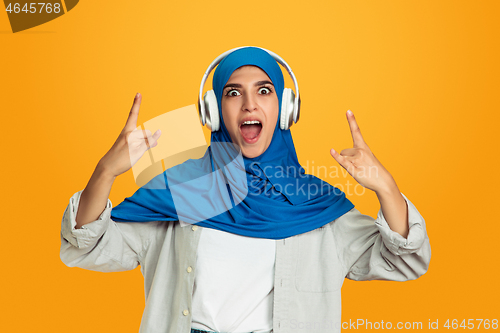 Image of Portrait of young muslim woman isolated on yellow studio background