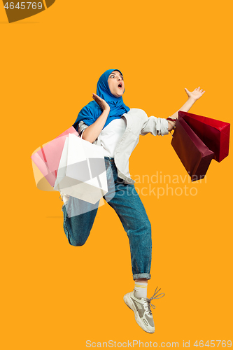 Image of Portrait of young muslim woman isolated on yellow studio background