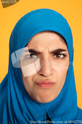 Image of Portrait of young muslim woman isolated on yellow studio background