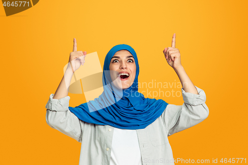 Image of Portrait of young muslim woman isolated on yellow studio background