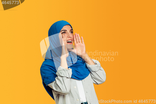 Image of Portrait of young muslim woman isolated on yellow studio background