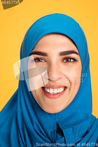 Image of Portrait of young muslim woman isolated on yellow studio background