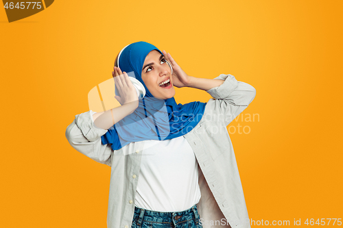 Image of Portrait of young muslim woman isolated on yellow studio background