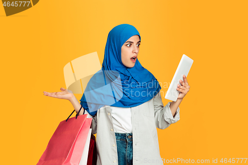 Image of Portrait of young muslim woman isolated on yellow studio background