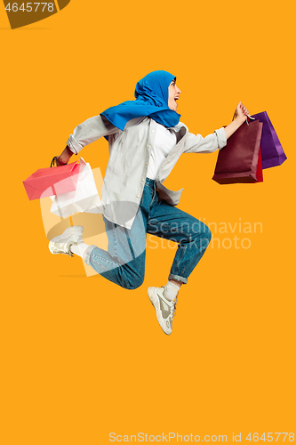 Image of Portrait of young muslim woman isolated on yellow studio background