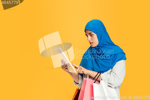 Image of Portrait of young muslim woman isolated on yellow studio background