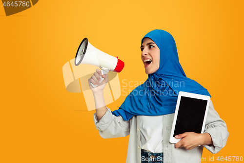 Image of Portrait of young muslim woman isolated on yellow studio background