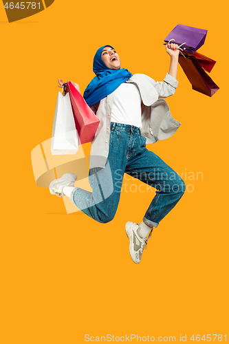 Image of Portrait of young muslim woman isolated on yellow studio background