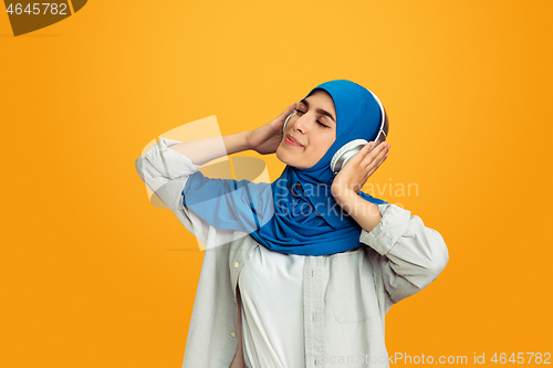 Image of Portrait of young muslim woman isolated on yellow studio background