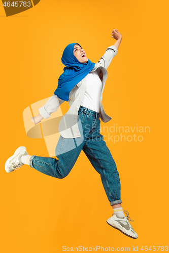 Image of Portrait of young muslim woman isolated on yellow studio background