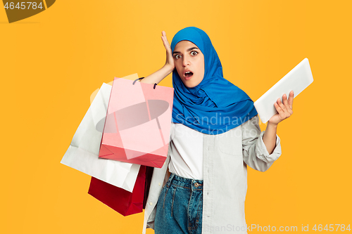 Image of Portrait of young muslim woman isolated on yellow studio background