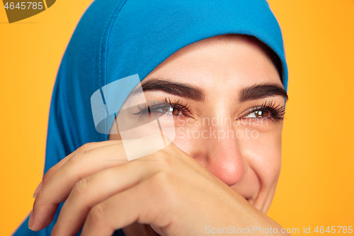 Image of Portrait of young muslim woman isolated on yellow studio background