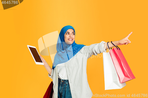 Image of Portrait of young muslim woman isolated on yellow studio background