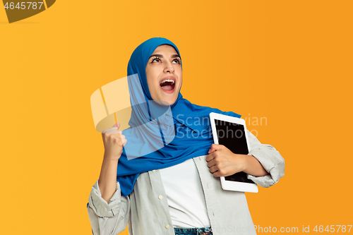 Image of Portrait of young muslim woman isolated on yellow studio background