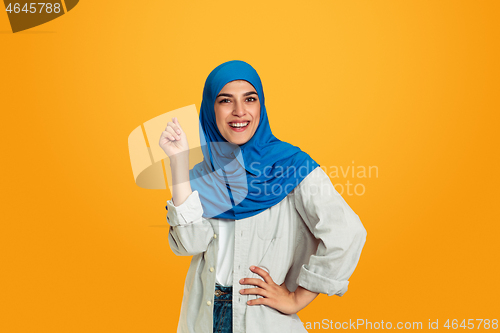 Image of Portrait of young muslim woman isolated on yellow studio background