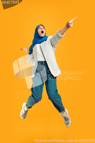 Image of Portrait of young muslim woman isolated on yellow studio background