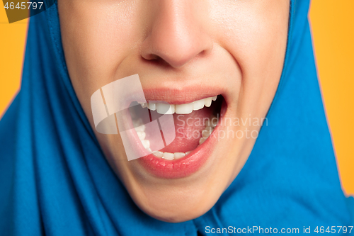 Image of Portrait of young muslim woman isolated on yellow studio background