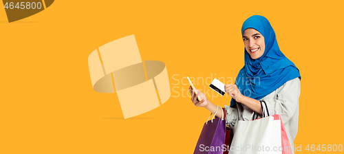 Image of Portrait of young muslim woman isolated on yellow studio background