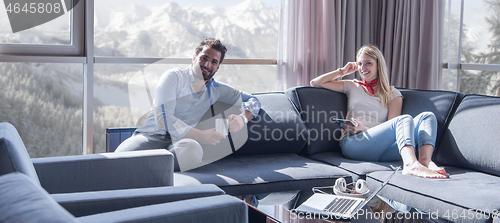 Image of couple relaxing at  home using tablet computer