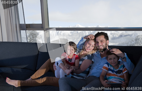 Image of happy young couple spending time with kids at home