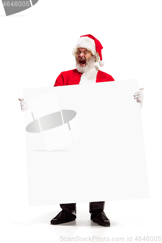 Image of Happy Santa Claus pointing on blank advertisement banner background with copy space. Smiling Santa Claus pointing in white blank sign