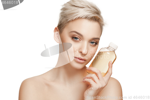 Image of Beauty concept. The pretty woman with perfect skin holding oil bottle