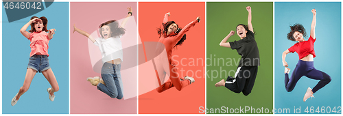 Image of Freedom in moving. Pretty young woman jumping against orange background