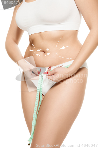 Image of Beauty body care. Woman holding the meter with hands and measuring waist.