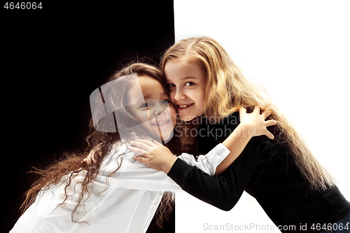 Image of portrait of two happy girls on a white and black background