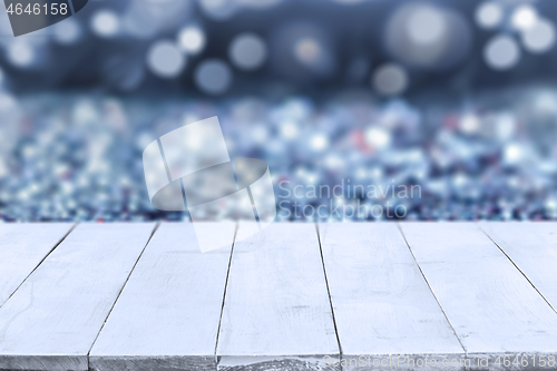 Image of Empty white wooden boards or table top over blue bokeh blurred background. Template, mockup for display or montage of products. Close up, copy space