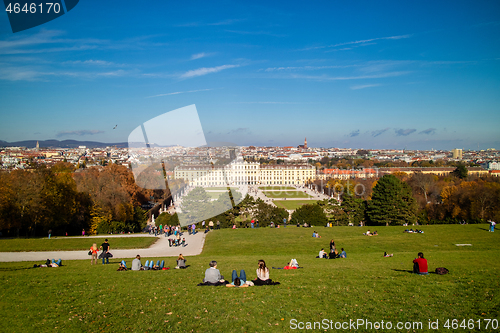 Image of Sitting people on a grass before Schonbrunn Palace in Vienna, Austria.