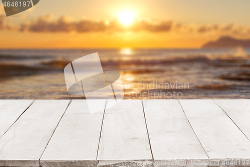 Image of Empty white wooden boards or countertop against seascape with sunset on background. Template, mockup for display or montage of products. Close up