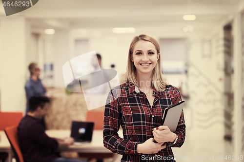 Image of portrait of young business woman at office with team in backgrou