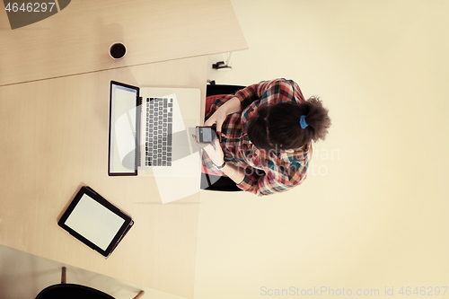 Image of top view of young business woman working on laptop