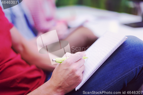 Image of male student taking notes in classroom