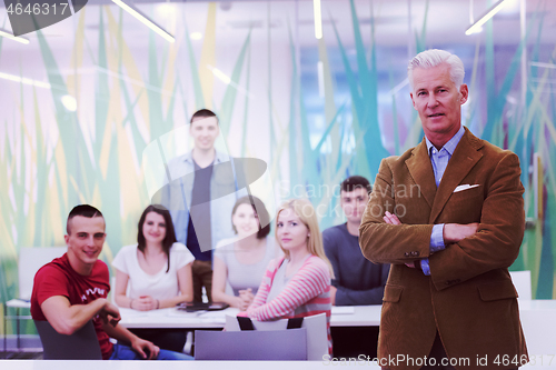 Image of portrait of  teacher with students group in background