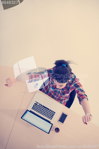 Image of top view of young business woman working on laptop