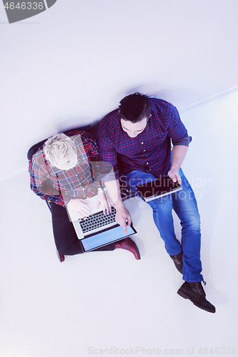 Image of top view of  couple working on laptop computer at startup office