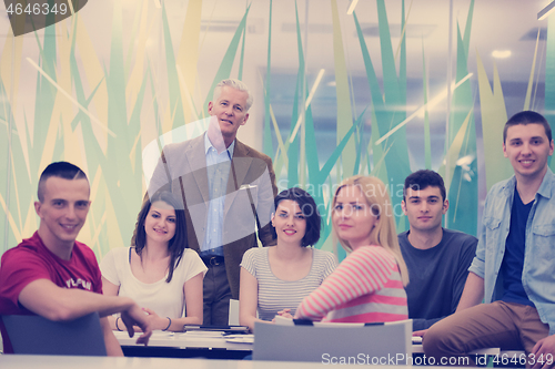 Image of portrait of  teacher with students group in background