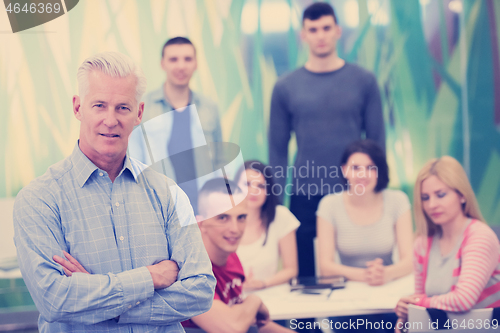 Image of portrait of  teacher with students group in background