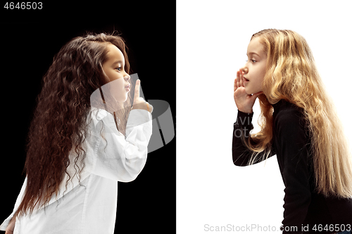 Image of The young teen girls whispering a secret behind her hand over pink background